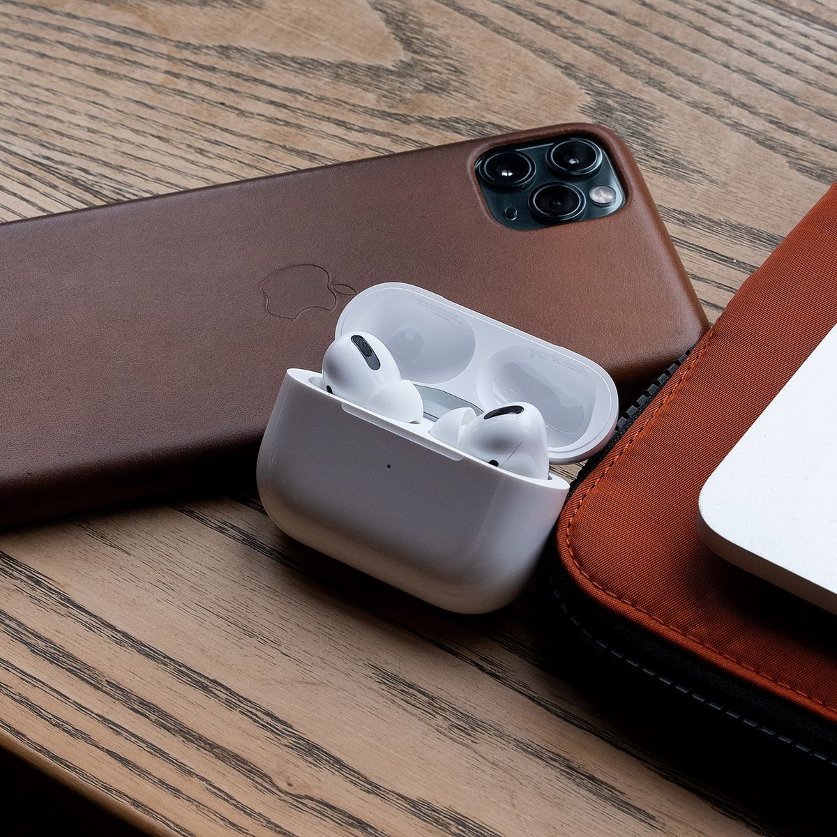 The AirPods Pro, the best wireless earbuds for people who use Apple products, pictured next to an iPhone 11 Pro Max and MacBook Pro.