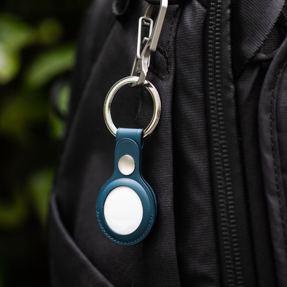 An AirTag in an Apple keychain accessory