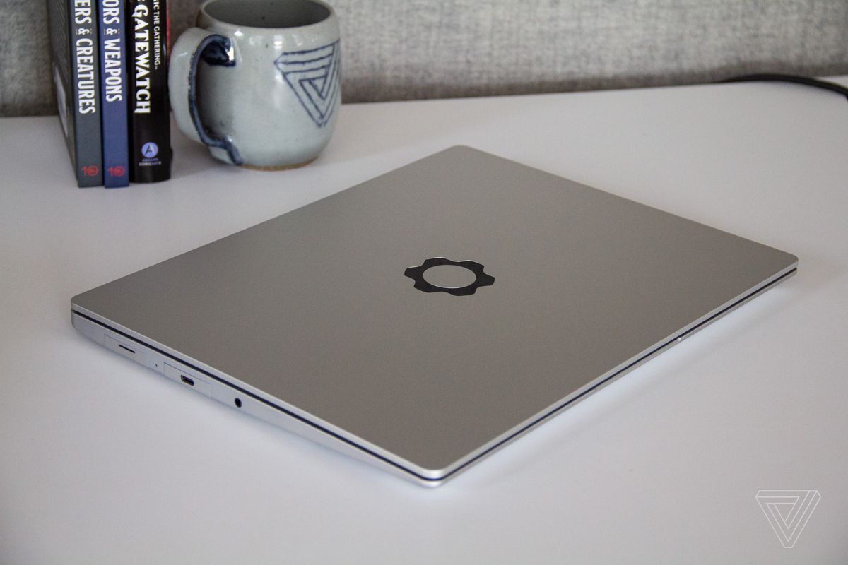 The Framework Laptop closed on top of a desk with a Verge-branded mug in the background.