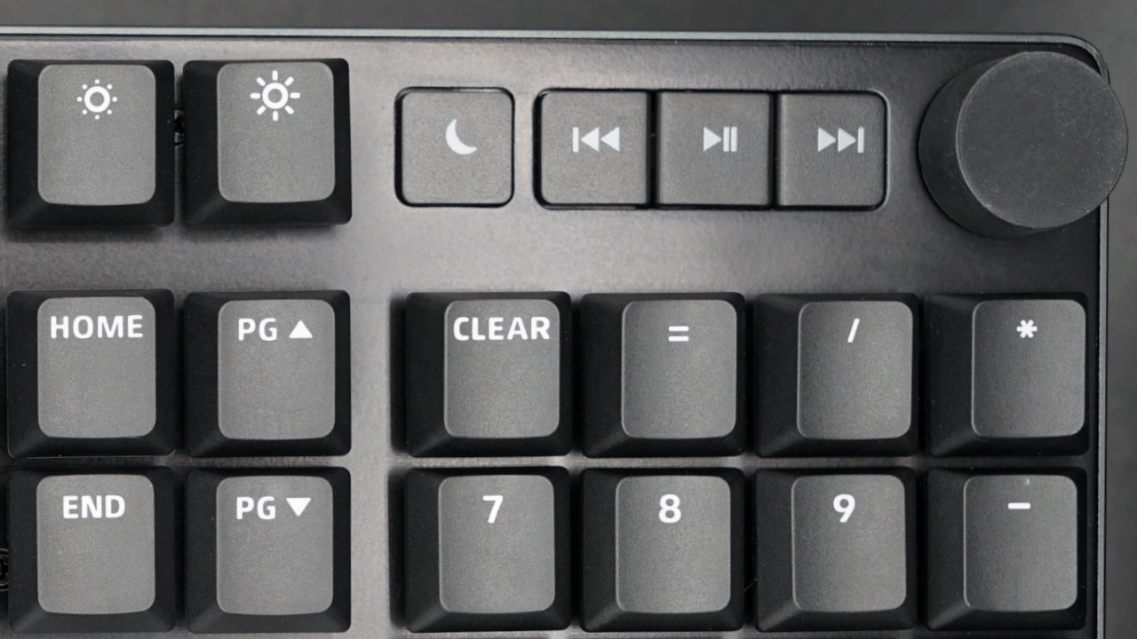 Dedicated media buttons are located next to a volume knob