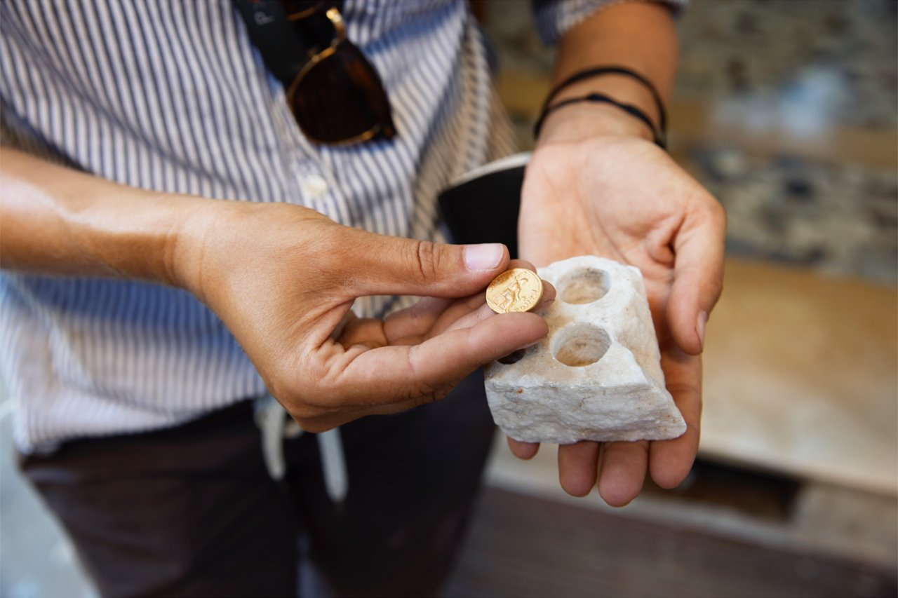 Dr. Allison Emmerson with the incredibly rare aureus, a gold coin discovered by her team