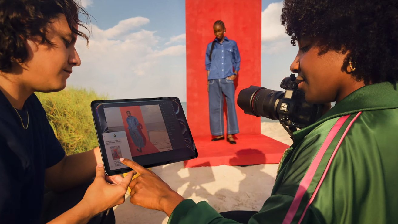 Two photographers look at an iPad Pro with a model in the background