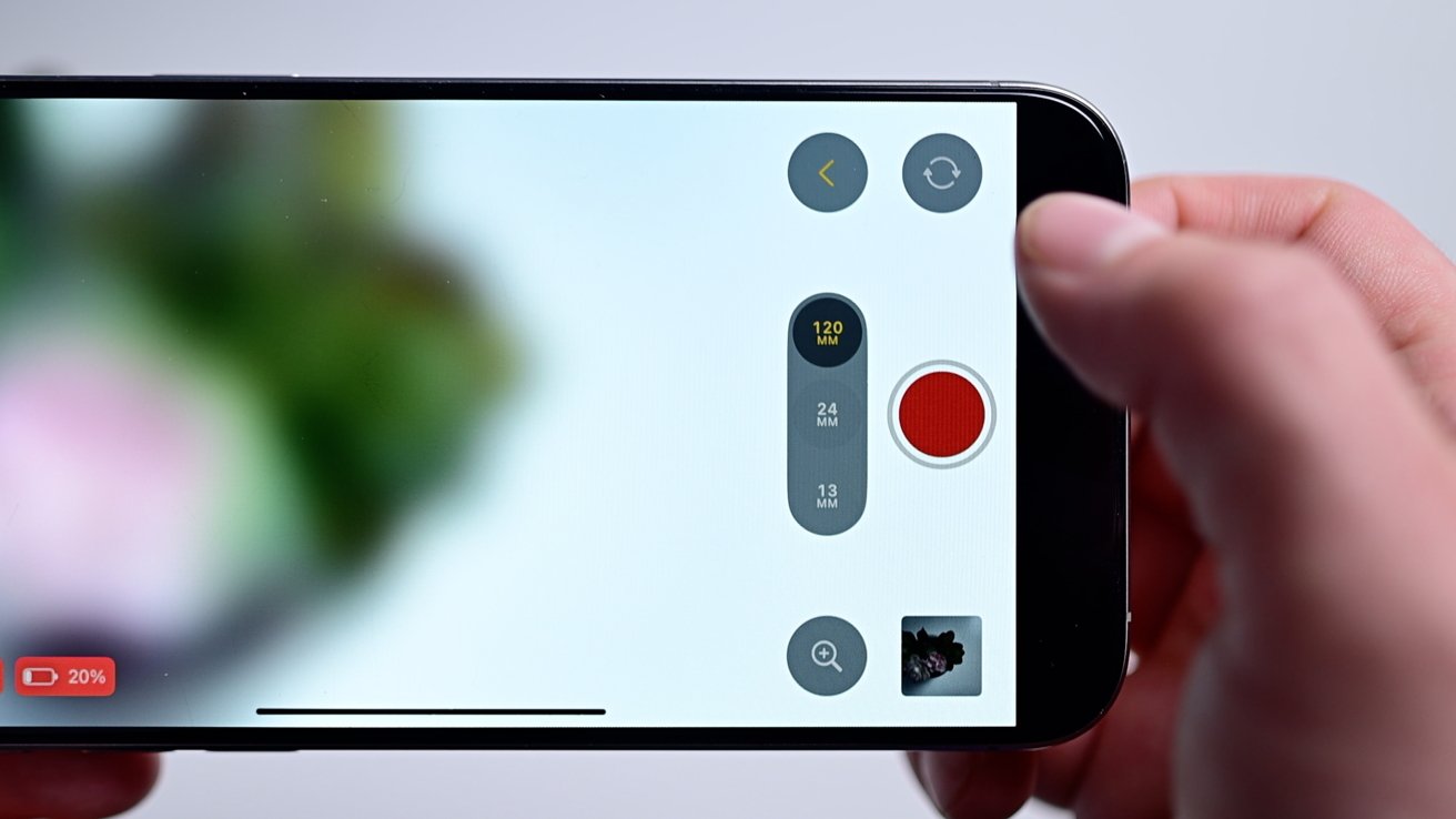 Closeup of the Final Cut Camera app's right-side controls including the shutter button in the middle, the gallery button on the bottom, the camera toggle on top, and  buttons for each of the three focal distances. All above a white table with a plant.