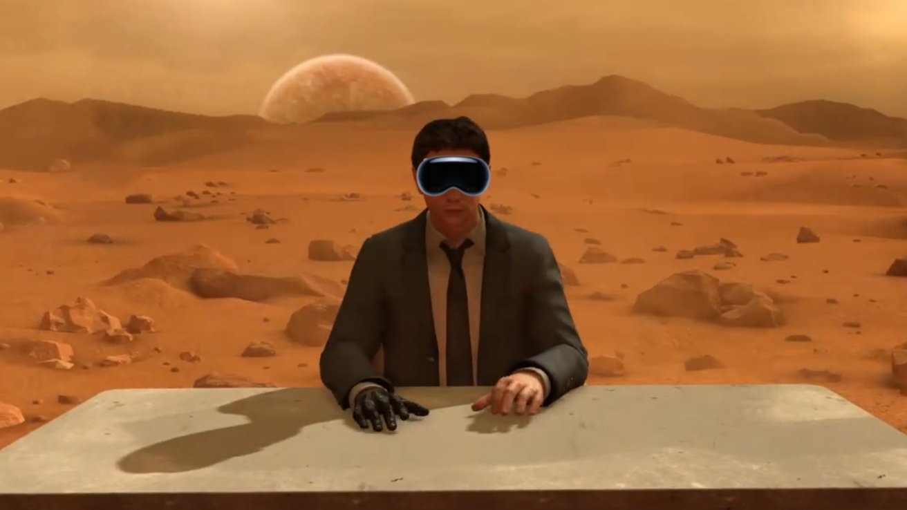 A man sits at a desk in a virtual environment modeled after an alien Mars-like planet. He's wearing Apple Vision Pro in the mockup.