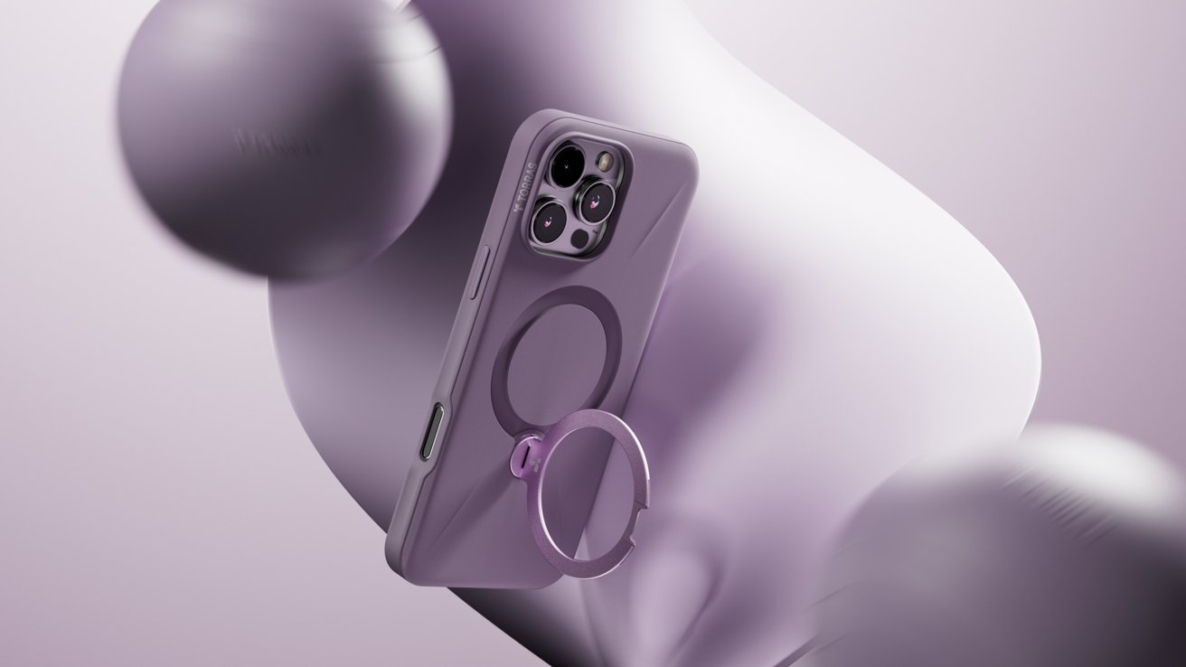 A purple smartphone case with a ring holder on the back, surrounded by abstract, blurred shapes in light purple tones.